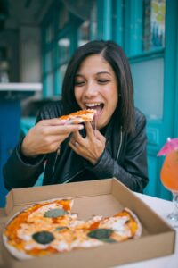 photo of woman eating pizza